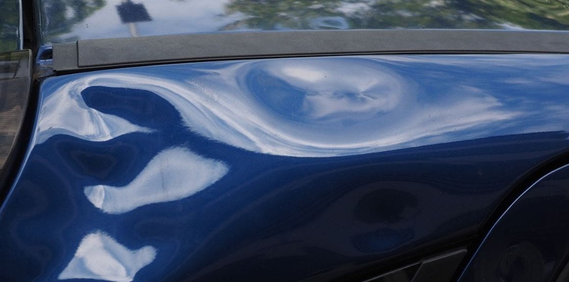 Many dents on blue car's body