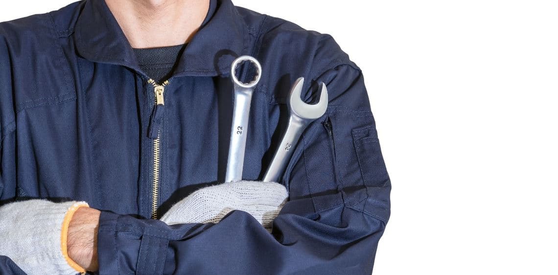 A car mechanic holds tools to maintain a car